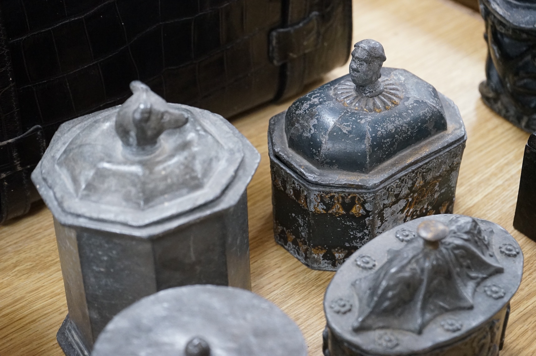 A collection of ten early 19th century lead tobacco boxes, to include an octagonal example, decorated in relief with the remains of red and gilt paint, largest 13cm wide